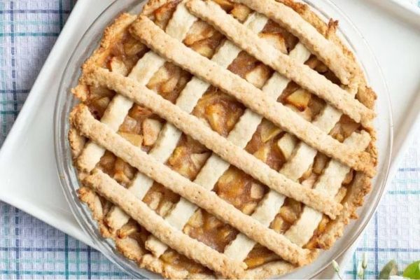 A lattice apple pie on a white plate.