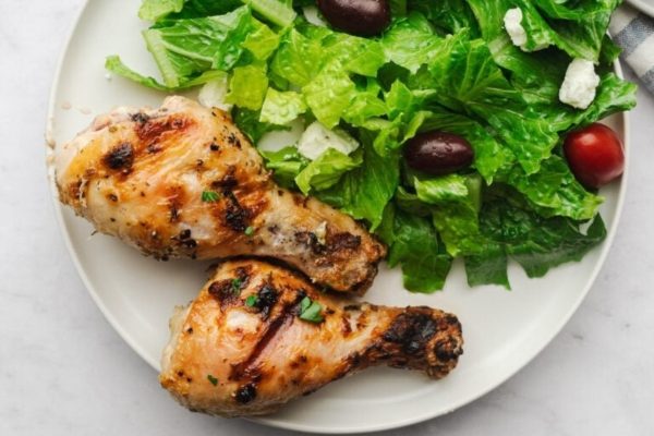 Chicken legs with vegetables on the side.