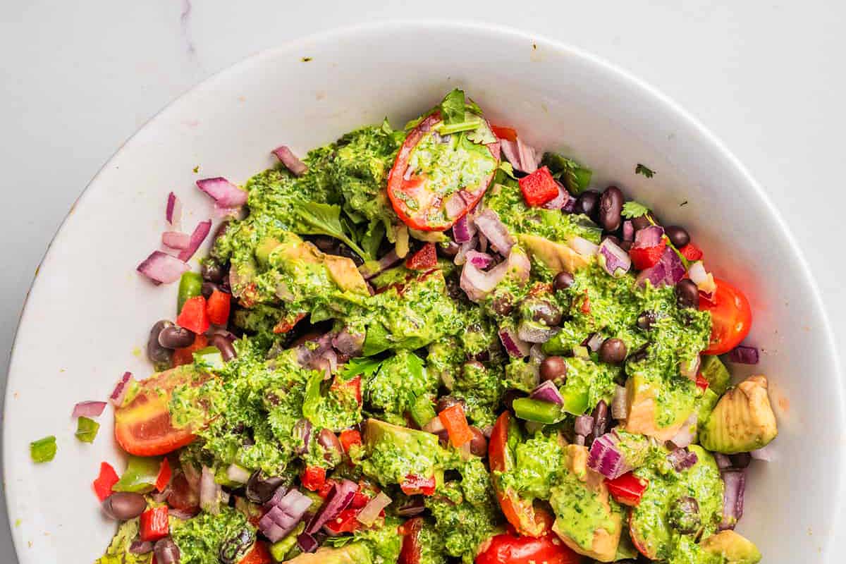 Avocado pesto salad in a white bowl.