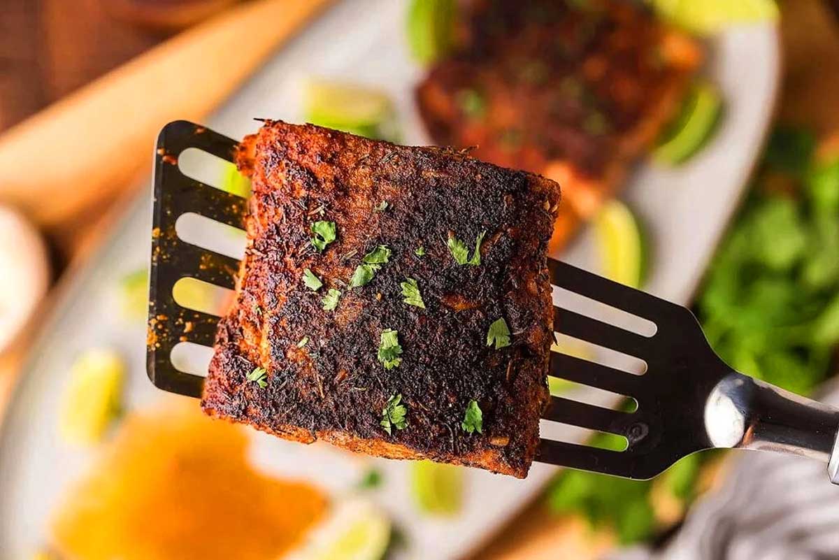 A spatula with a piece of meat on it.