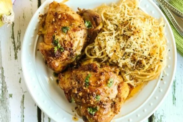 A plate with chicken and spaghetti on it.