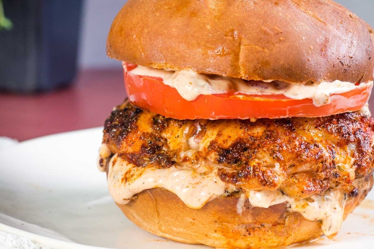 A chicken burger is served on a bun.