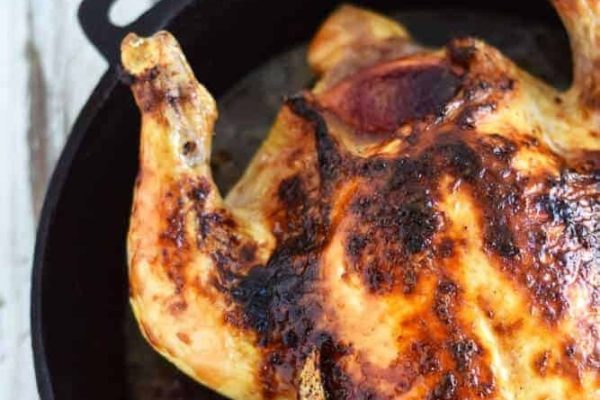 A roasted chicken in a cast iron skillet.