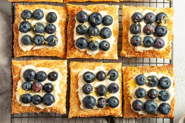 Blueberry and lemon tarts on a cooling rack.