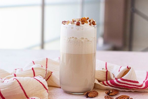 A milkshake with whipped cream and pecans.