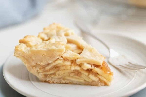 A slice of apple pie on a white plate.