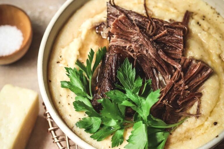 A bowl of soup with meat and parsley.