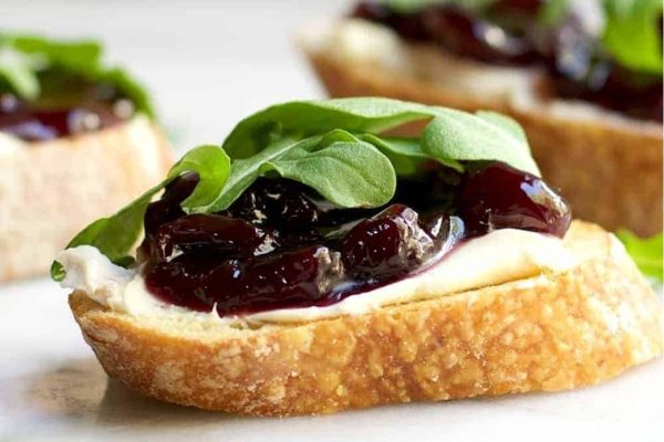 A plate of bruschetta with blue cheese and arugula.