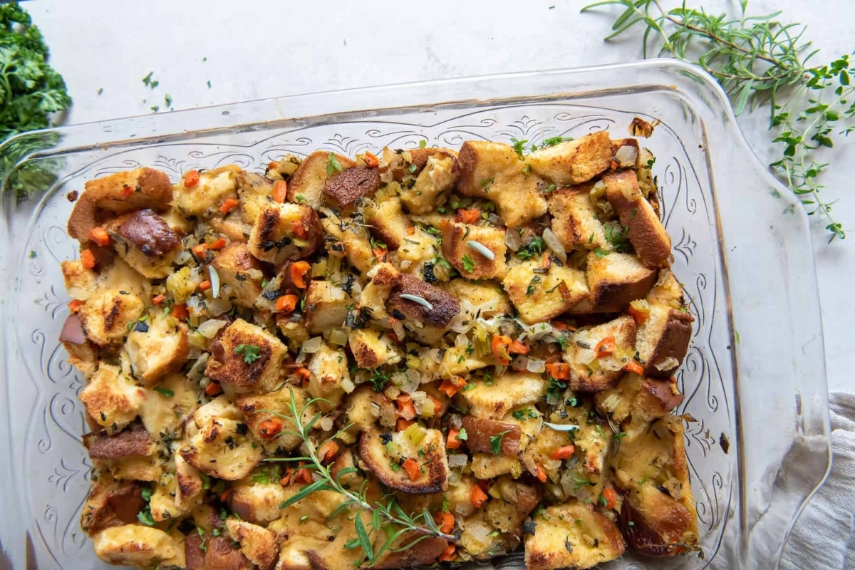 This recipe features delicious Thanksgiving stuffing baked in a glass dish with aromatic herbs.