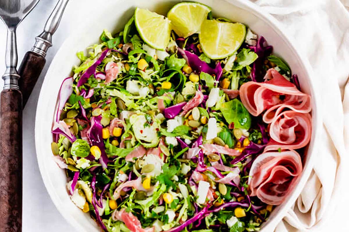 A bowl of slaw with ham and cranberries.