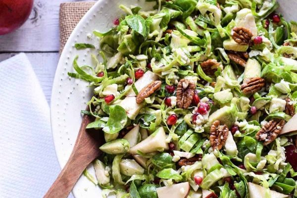 A colorful salad with brussels sprouts, apples, and pomegranate - perfect for Christmas.