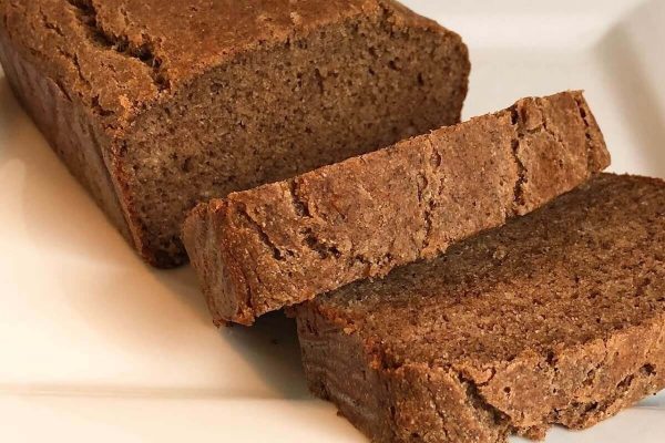 Two slices of brown bread on a white plate.