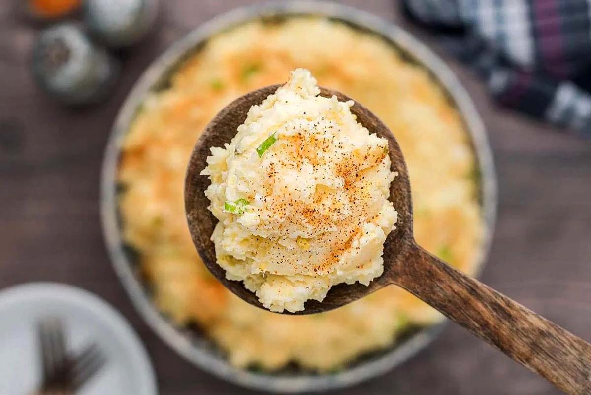 Potato salad being scooped by a spoon.