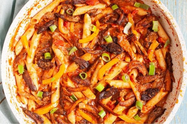 A Penne casserole dish filled with meat and vegetables.