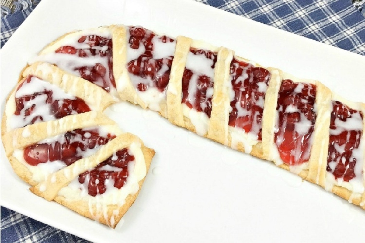 A white plate with a strawberry danish on it, perfect for holiday baking.