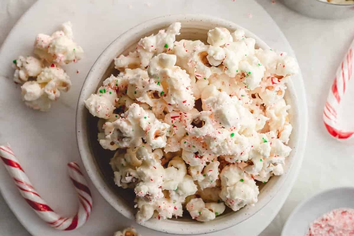 A bowl of popcorn with candy canes.
