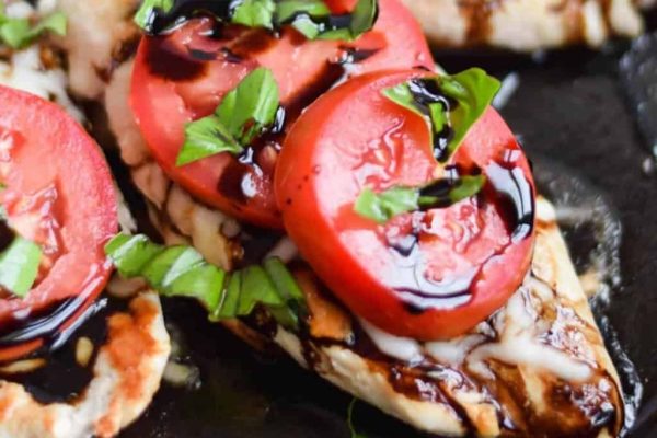 Grilled chicken breasts with tomatoes and basil.