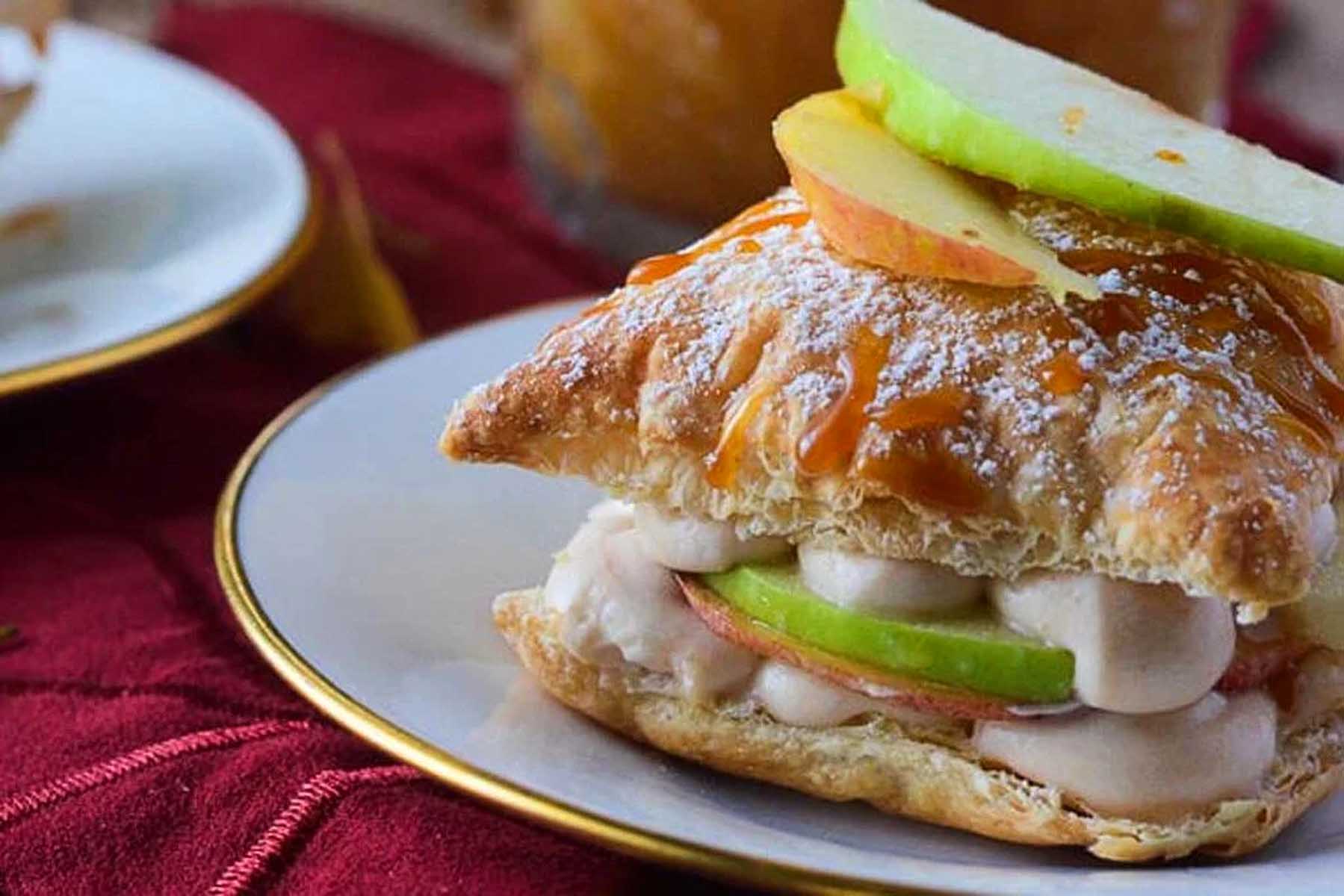 A sandwich with apples and caramel on a plate.
