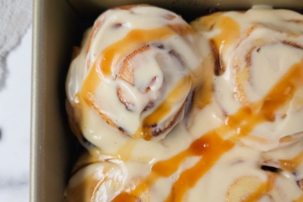Cinnamon rolls in a pan with caramel sauce. Enjoy the mouthwatering combination of warm, fluffy cinnamon rolls blanketed in a decadent caramel sauce.
