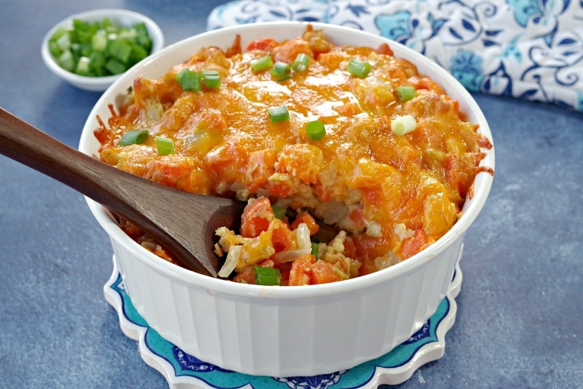 A white bowl filled with rice, carrots, and a side of ham.