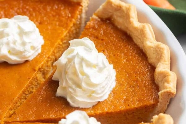 A slice of pumpkin pie with whipped cream.