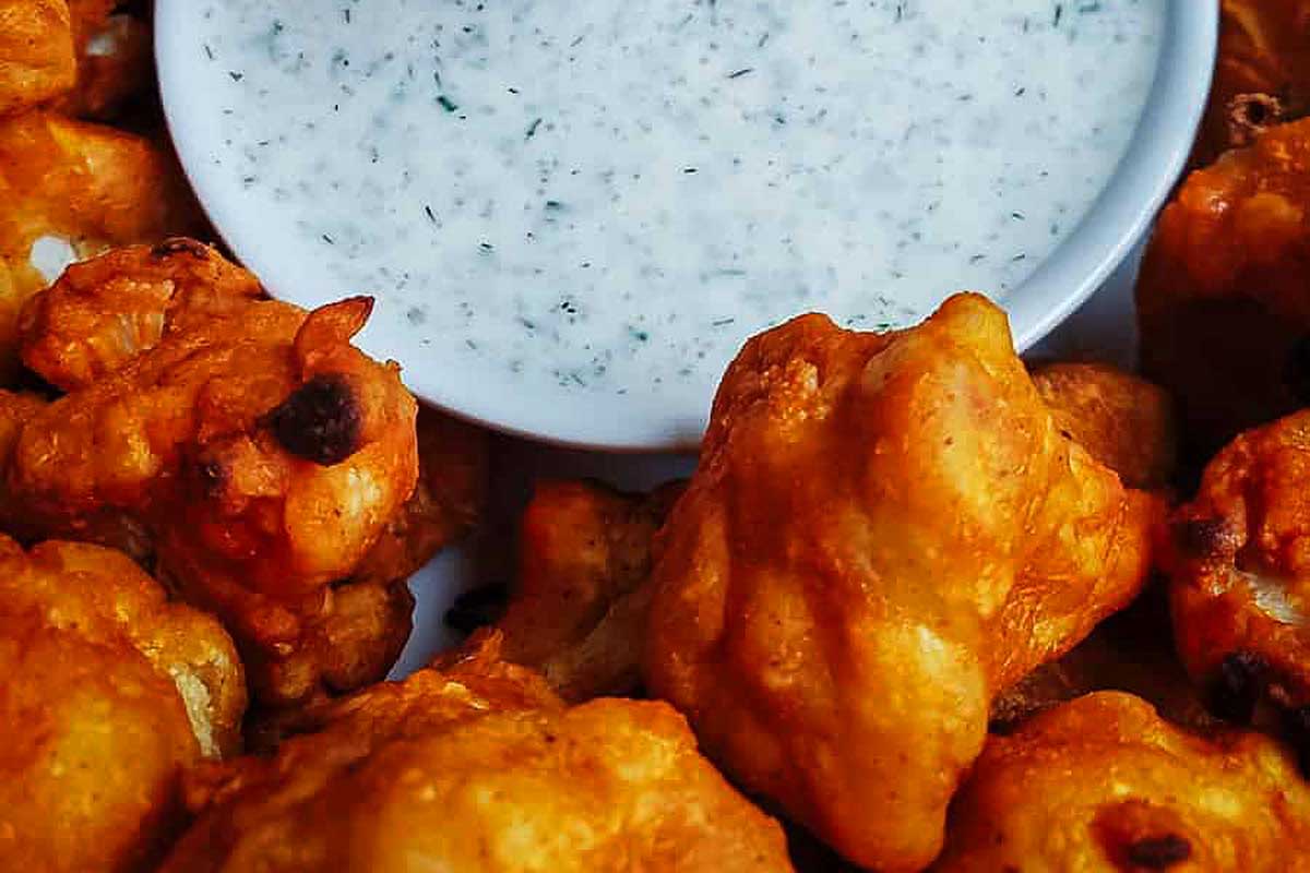 A plate of fried calamari, a popular pub and bar food, served with a flavorful dip.