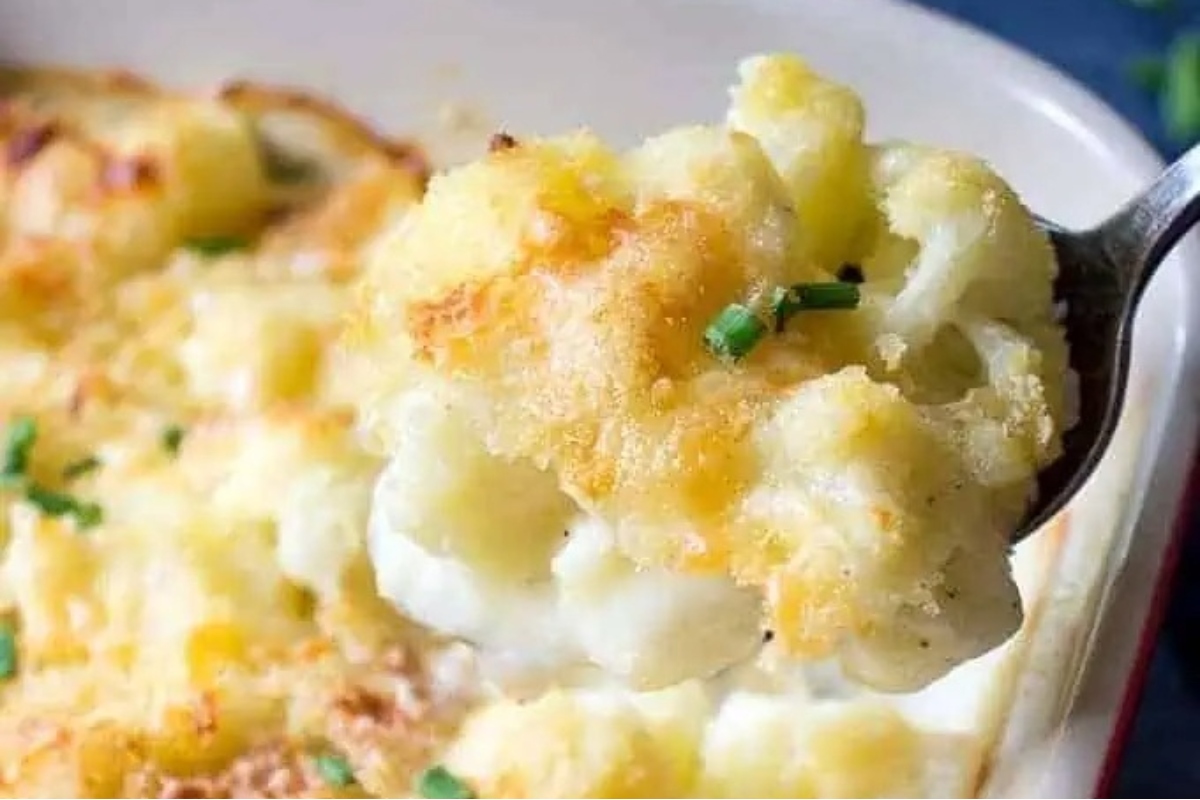 A spoonful of cheesy cauliflower casserole, perfect as a side dish for turkey.