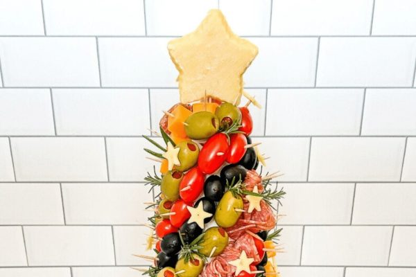 A festive Charcuterie Board adorned with Christmas-themed meats and olives.