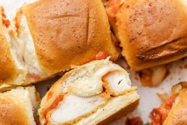 Chicken parmigiana sliders on a white plate.
