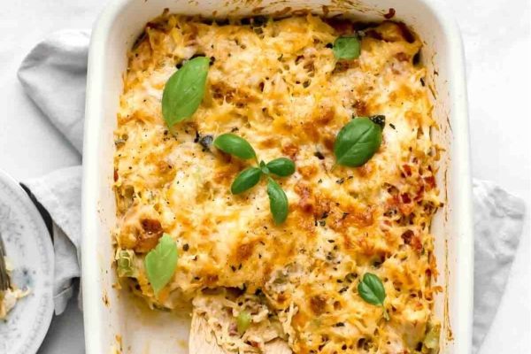 A casserole dish with chicken and broccoli in it.