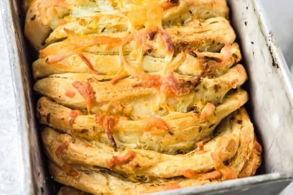 A loaf of cheesy bread in a pan.