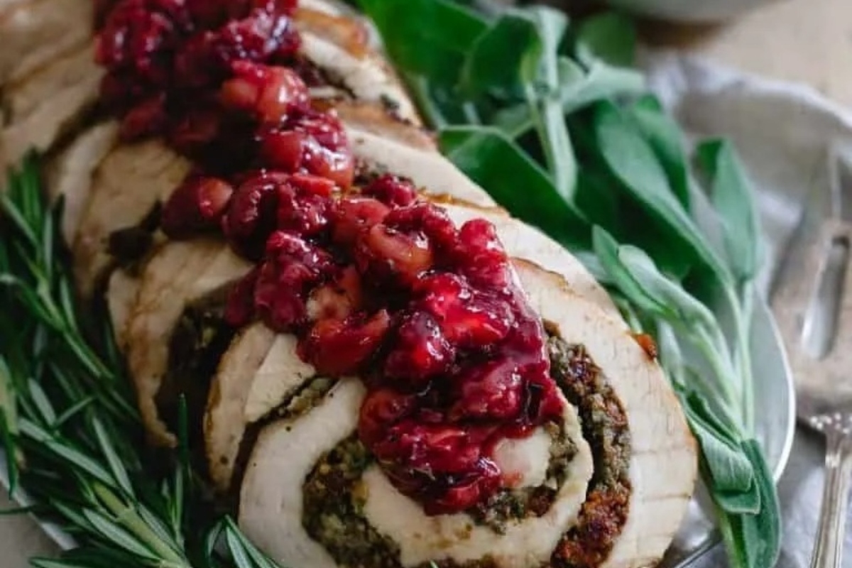 An elegant Thanksgiving recipe featuring a turkey stuffed with cranberry sauce, beautifully presented on a plate.
