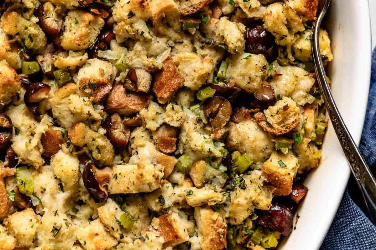 Make ahead Thanksgiving stuffing in a white dish with a spoon.