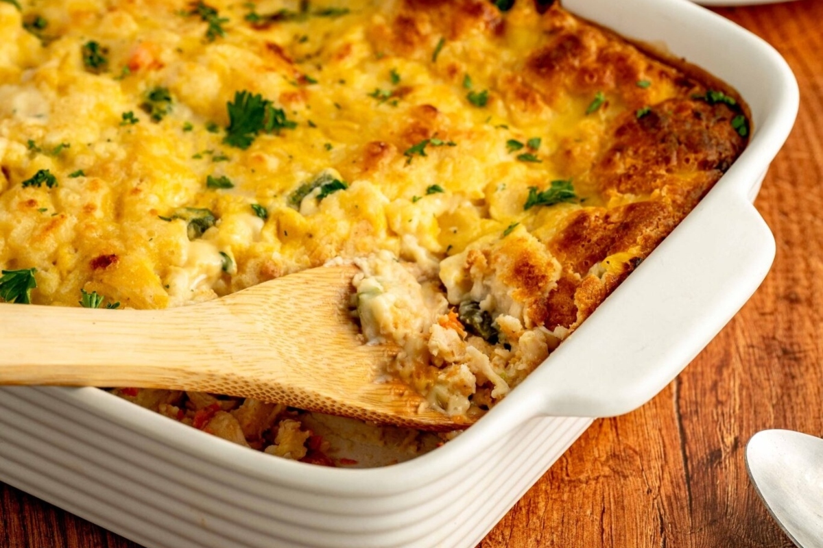 A casserole dish filled with a delicious combination of frozen mixed vegetables, cooked to perfection. Complete the ensemble by adding a touch of flavor with a wooden spoon for mixing. Discover mouthwatering recipes