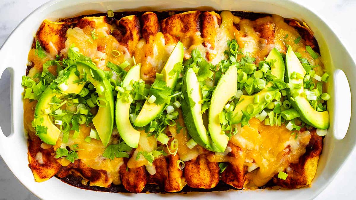 Scrumptious rotisserie chicken enchiladas in a white baking dish.