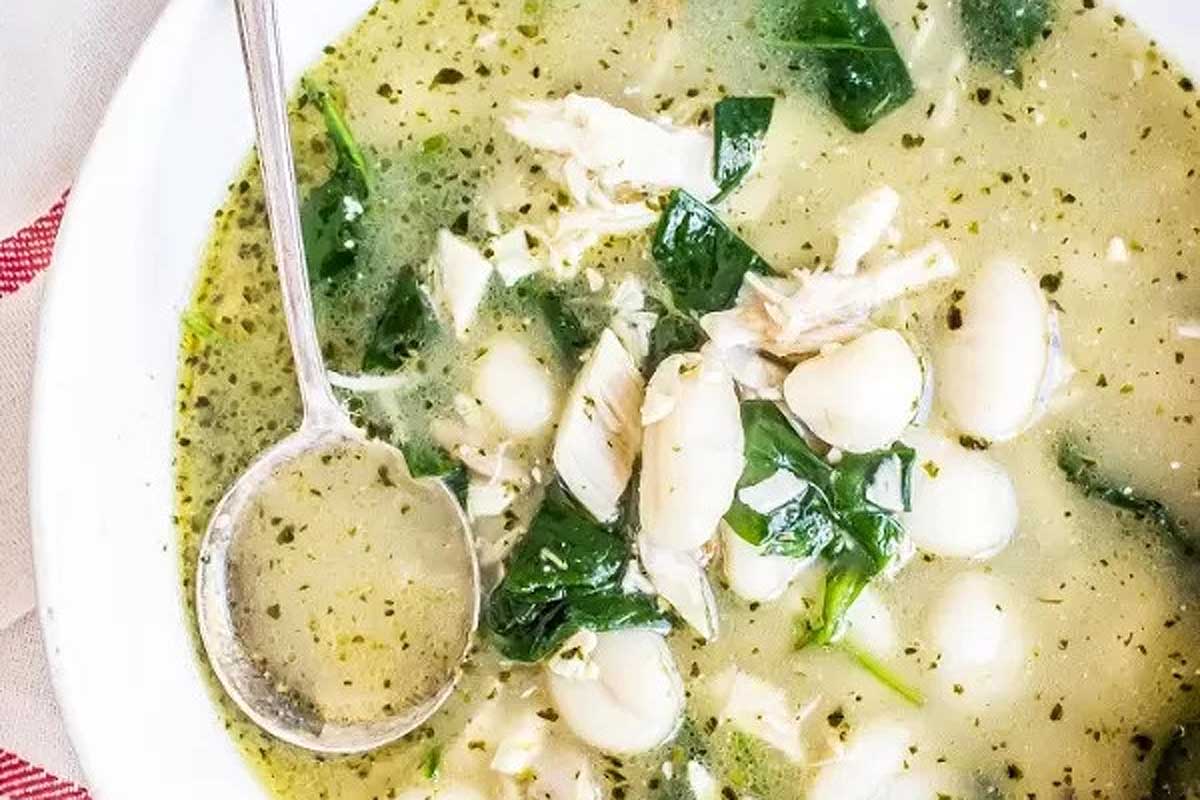 A bowl of chicken and spinach soup with gnocchi.