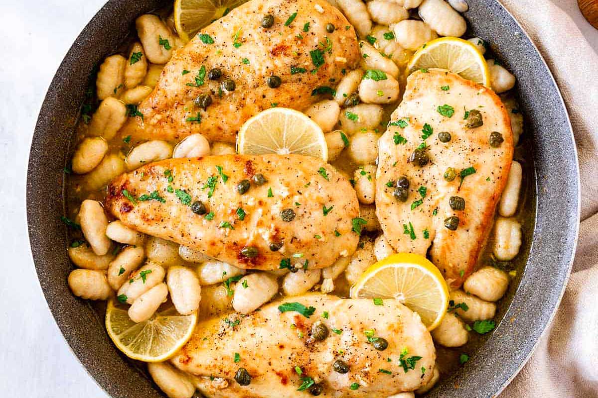 Lemon chicken and white beans in a skillet, perfect for easy weeknight recipes.
