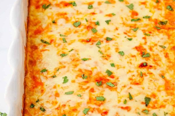 Cheesy mexican casserole in a white dish.