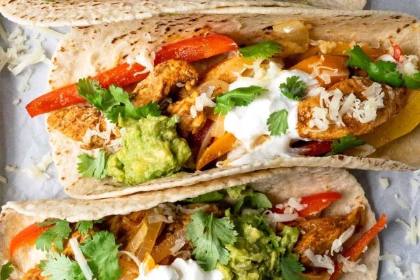 Chicken tacos with guacamole and sour cream.