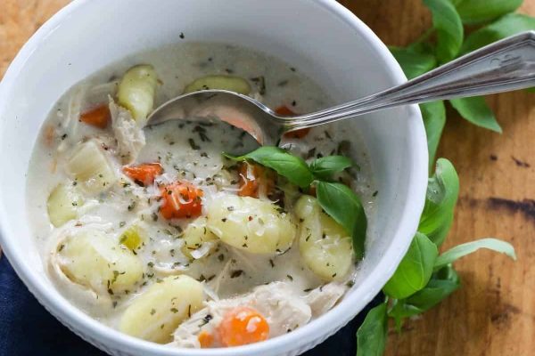 Chicken gnocchi in a white bowl with a spoon.