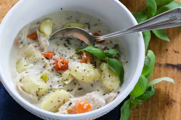 Chicken chowder in a white bowl with a spoon.