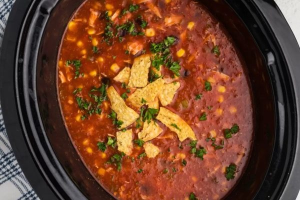 A crock pot full of mexican chicken soup.
