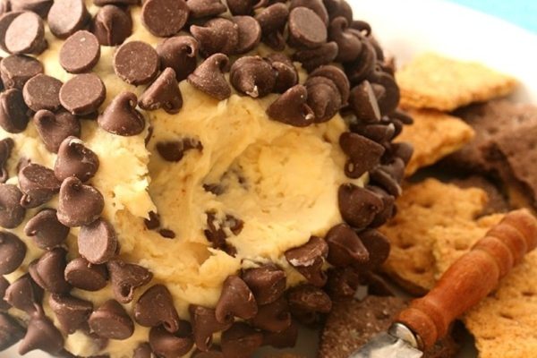 A plate with a chocolate covered cheese ball and a cracker, perfect for indulging in delicious cheese ball recipes.