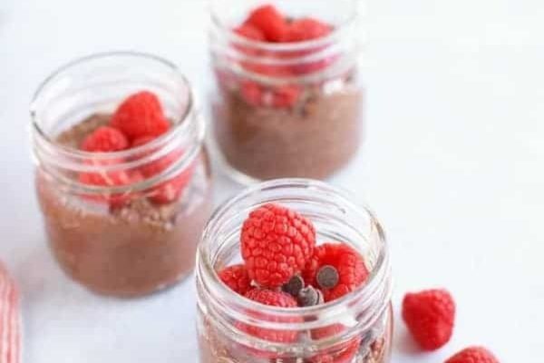 Meal prep chocolate mousse in mason jars with raspberries and chocolate chips.