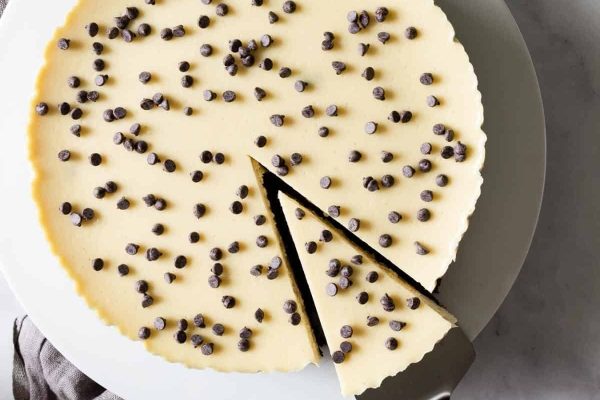 A cheesecake with chocolate chips on a plate.