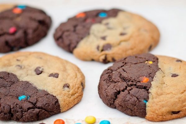 Four chocolate chip cookies with a chocolate chip in the middle, perfect for indulging in a sweet treat.