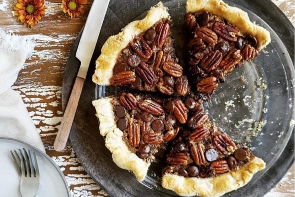 Chocolate pecan pie on a plate with a knife and fork.