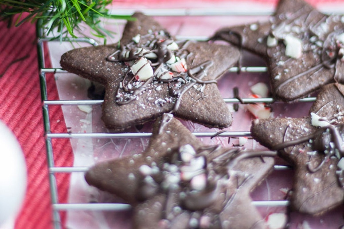 Candy Cane chocolate peppermint cookies with sprinkles on a cooling rack.