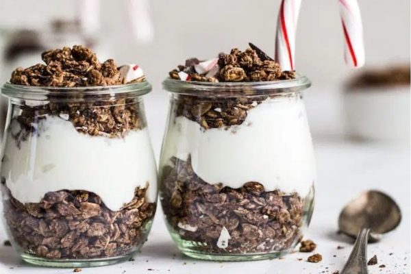 Two Christmas desserts - chocolate granola topped with cream and candy canes.