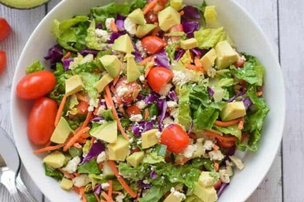 A bowl of salad, perfect for Meal Prep lunches, with creamy avocado, juicy tomatoes, and crunchy carrots.